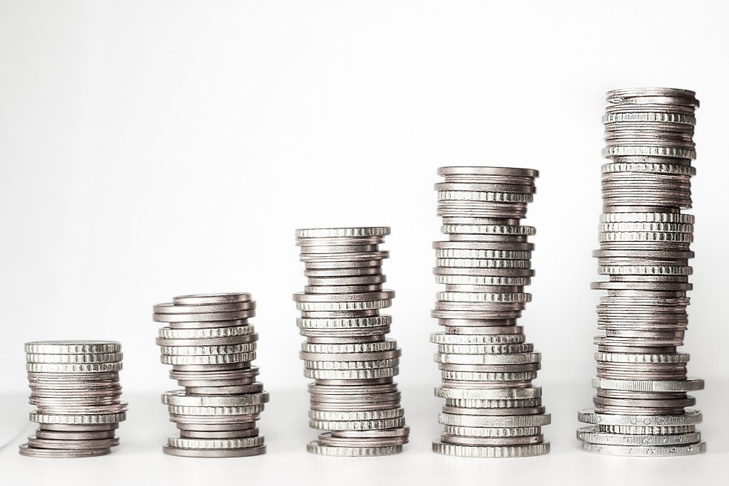 Silver coins stacked in five piles